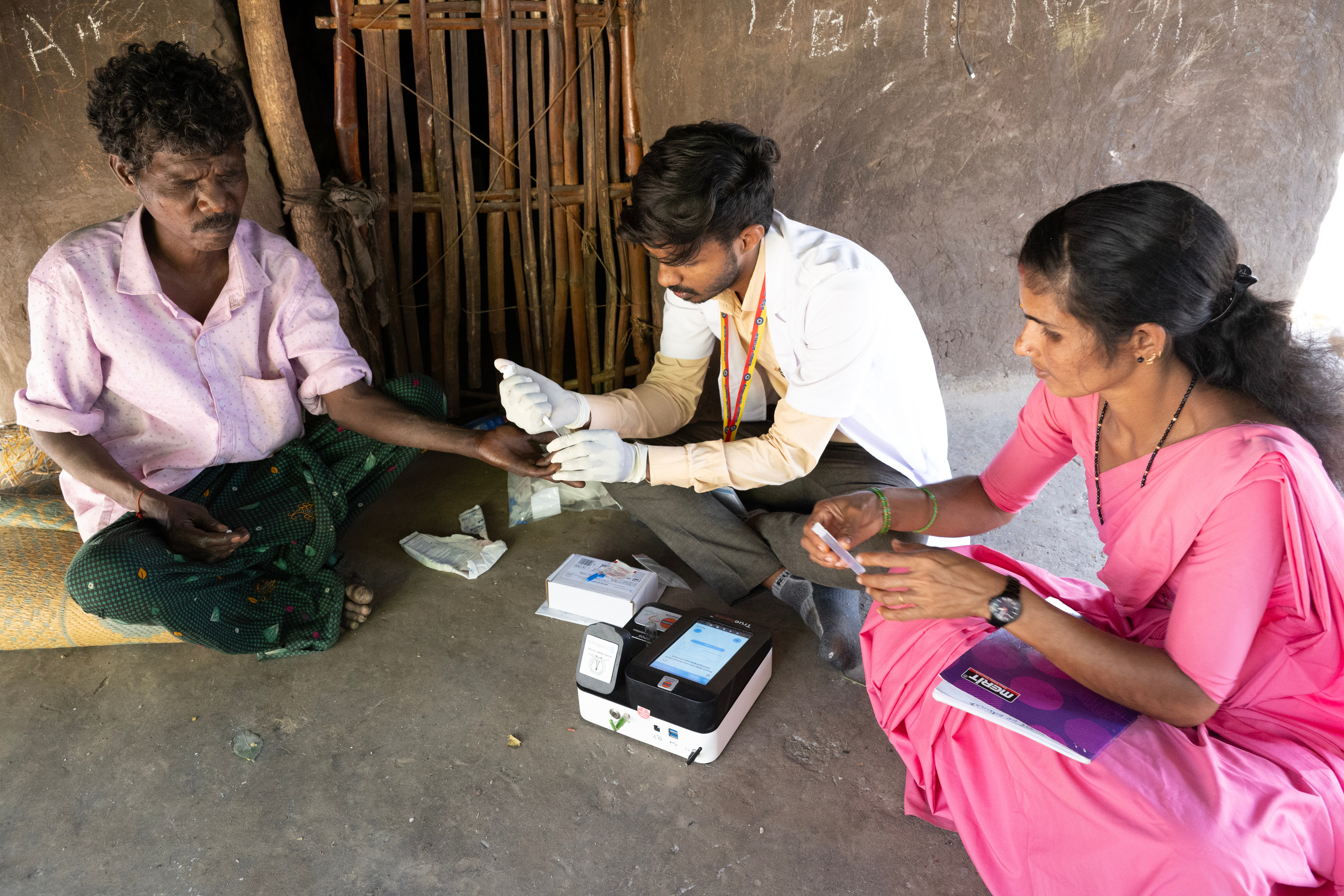 A field health team conducting a doorstep screening in a rural home